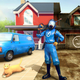 A man in a blue rubber suit stands in front of a house near a cat and a van.